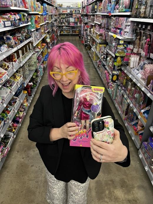 Kristin in a toy store aisle, thrilled to find a vintage-style doll